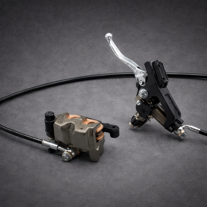 Hydraulic front brake system for Sur-Ron Ultra Bee — complete master cylinder, lever, caliper, and brake line on a gray background.